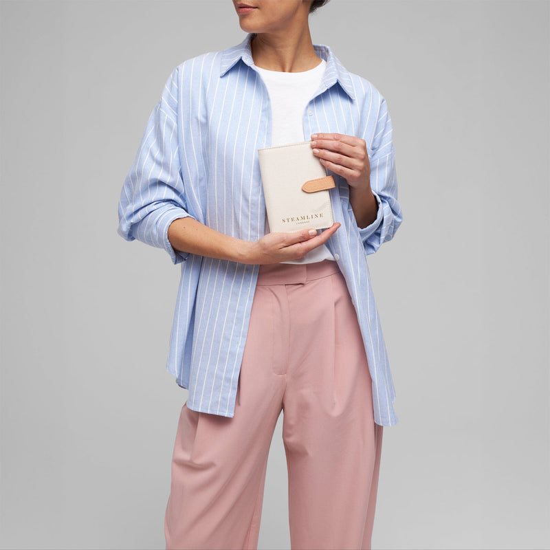 Model with the Navigator leather passport holder in white with desert glitter trim