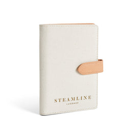 Angled view of the Navigator leather passport holder in white with desert glitter trim and logo