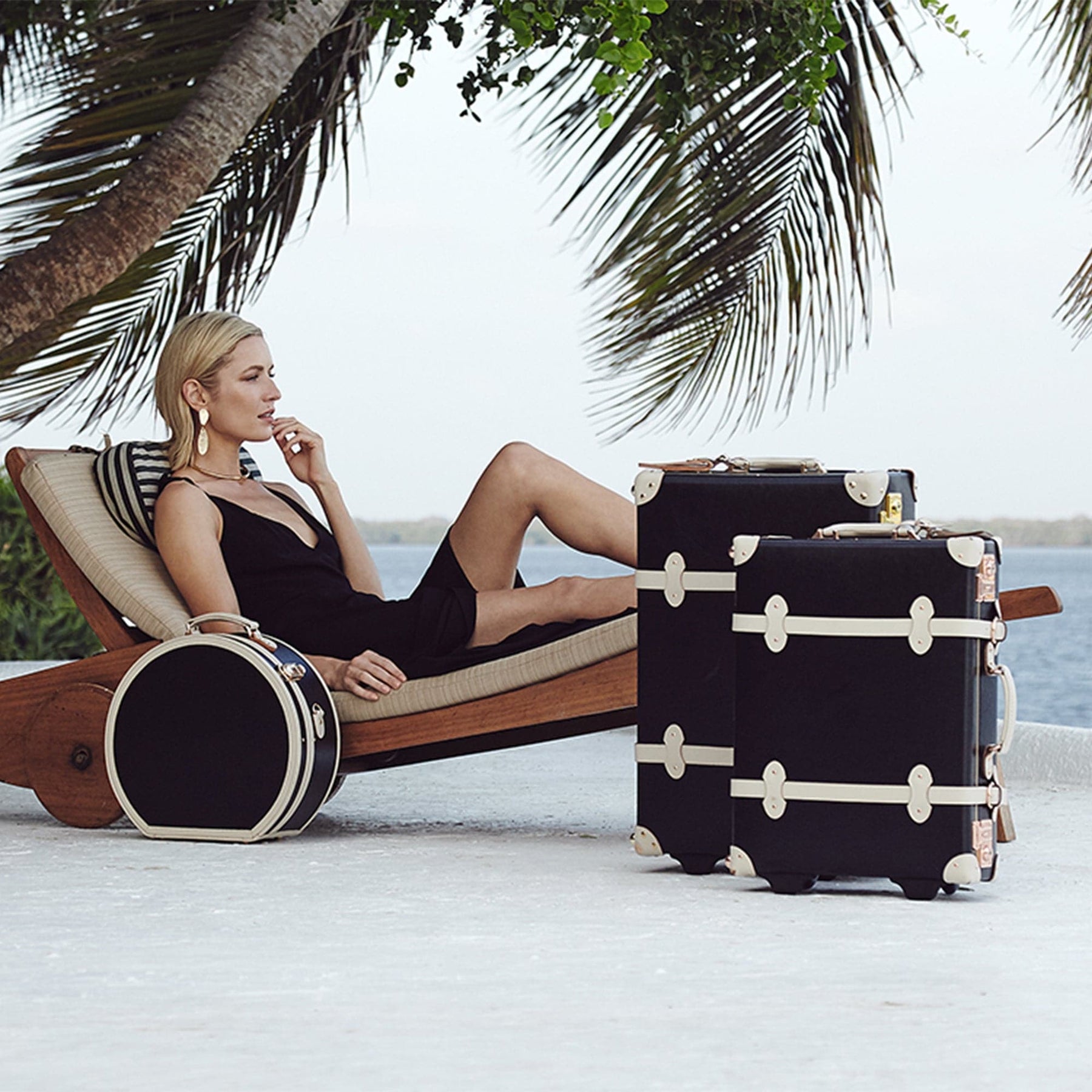 Lifestyle image of model with the Starlet fibreboard suitcases in black