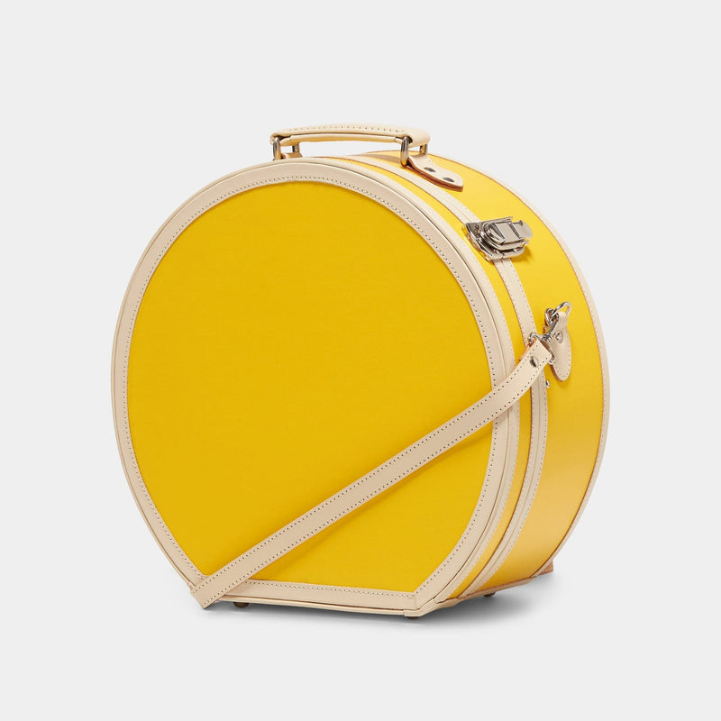 Angled product view of the large hatbox Correspondent fibreboard suitcase in canary yellow with detachable shoulder strap