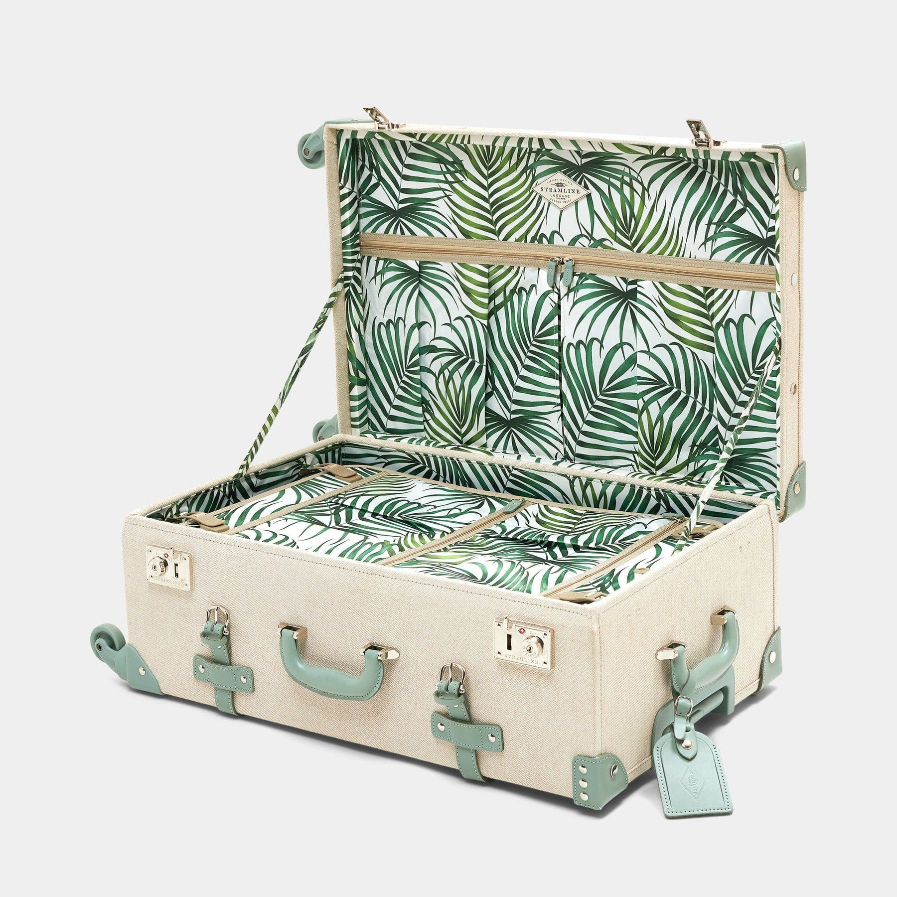 Open product view of the check-in spinner Editor linen suitcase with sea green trims, palm-leaf print lining and leather luggage tag