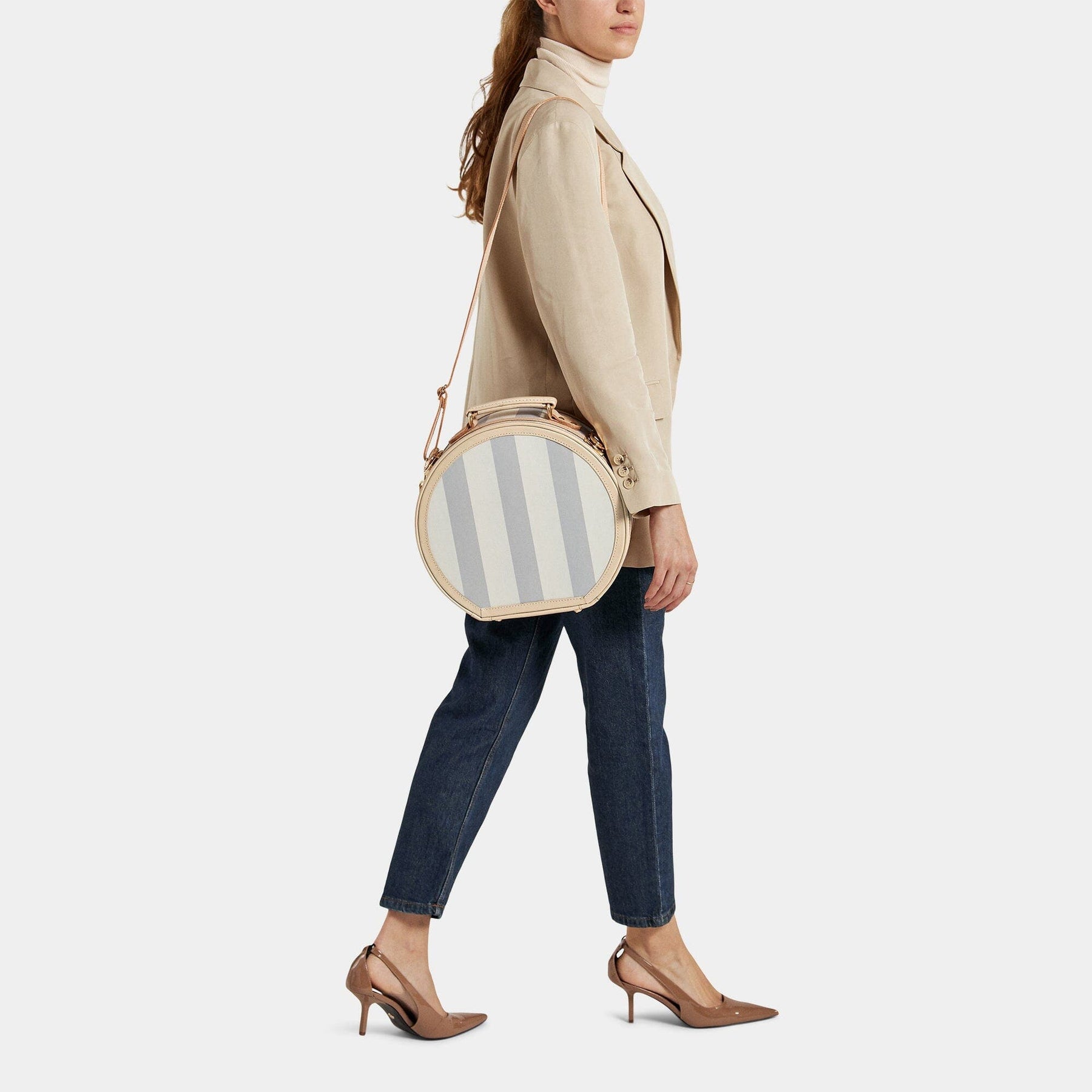 Model with the small hatbox Illustrator fibreboard suitcase in blue-stripe with shoulder attachment strap