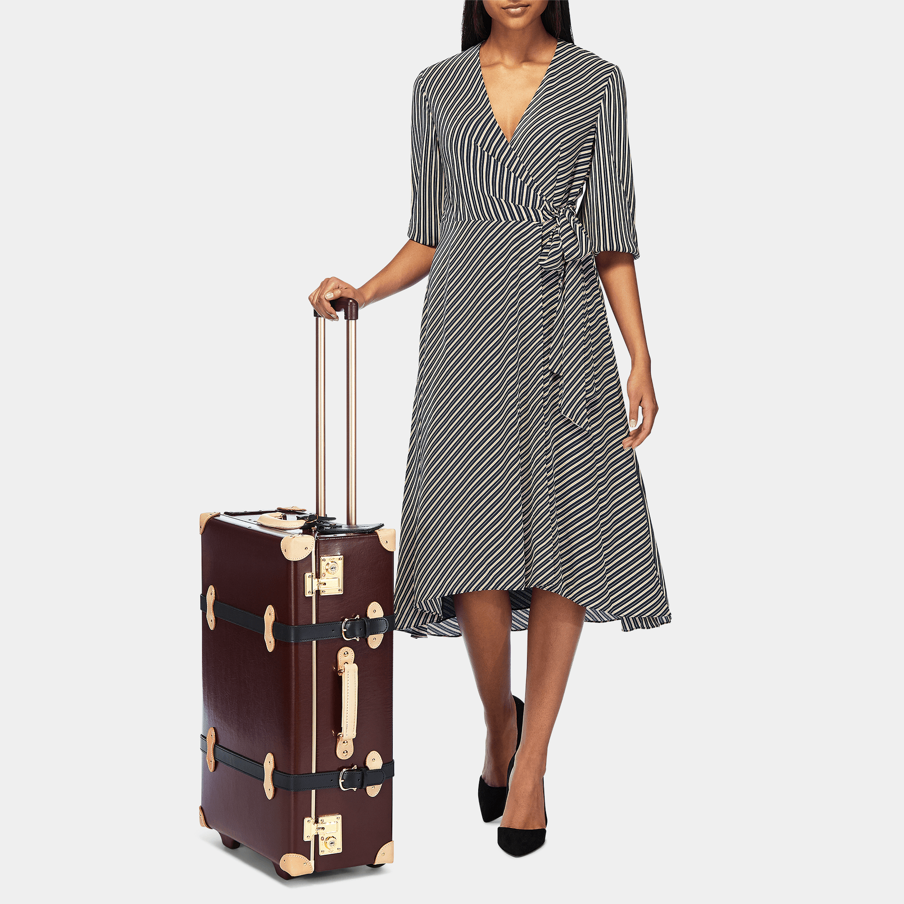 Model with the stowaway Architect leather suitcase in burgundy with raised handle