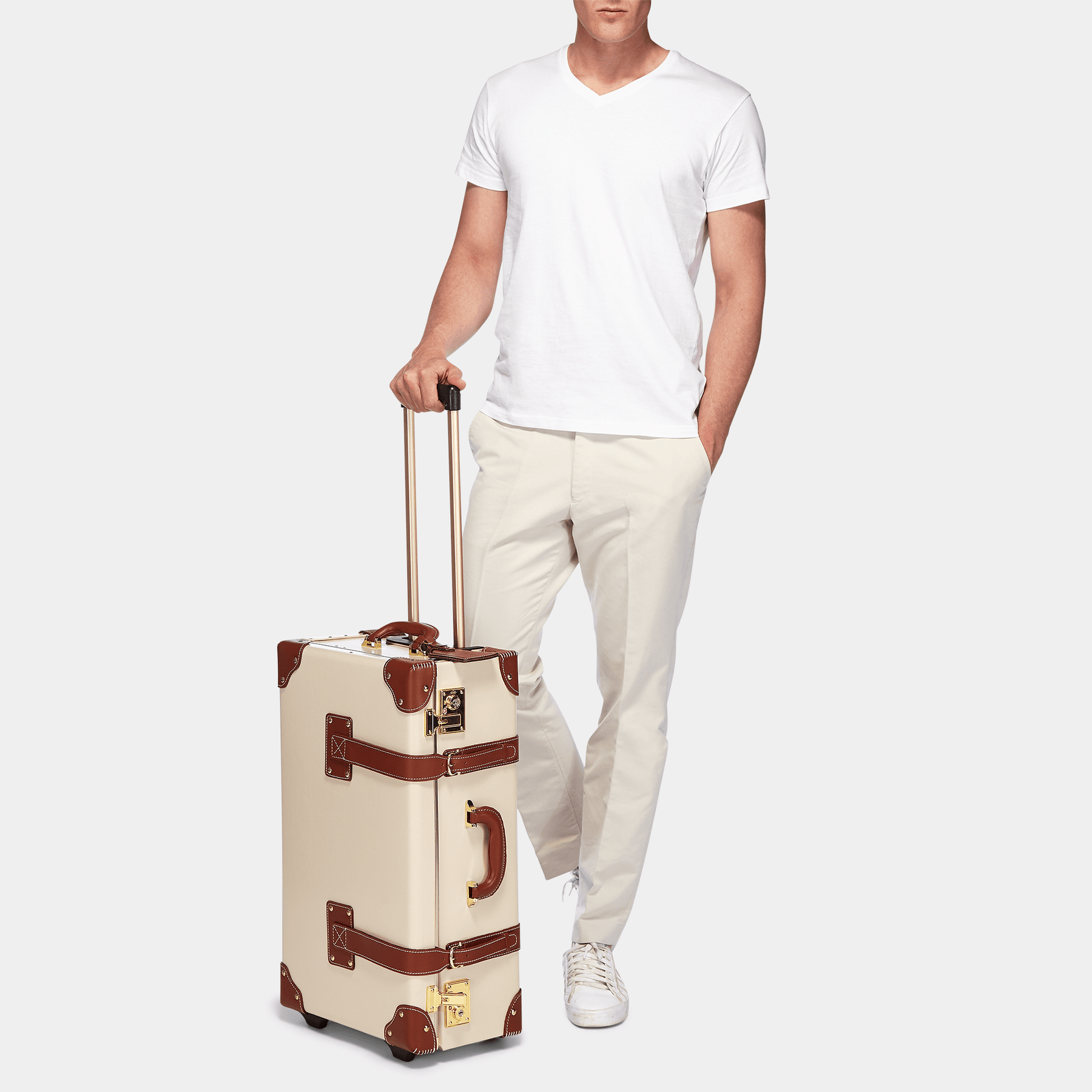 Male model with the stowaway Diplomat leather suitcase in cream with raised handle