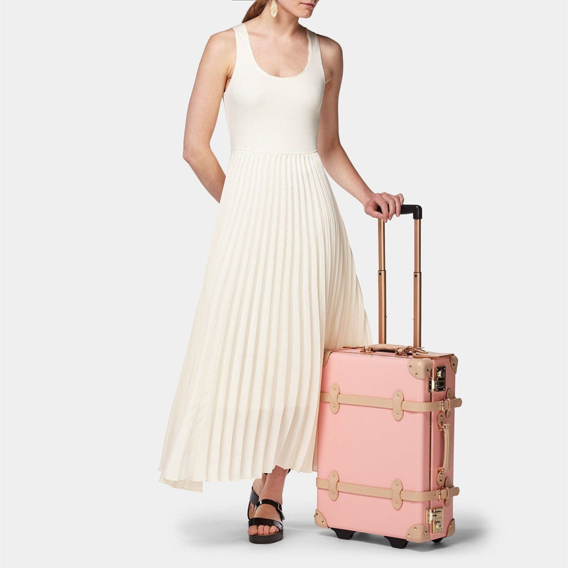 Model with the carry-on Correspondent fibreboard suitcase in pink with raised handle