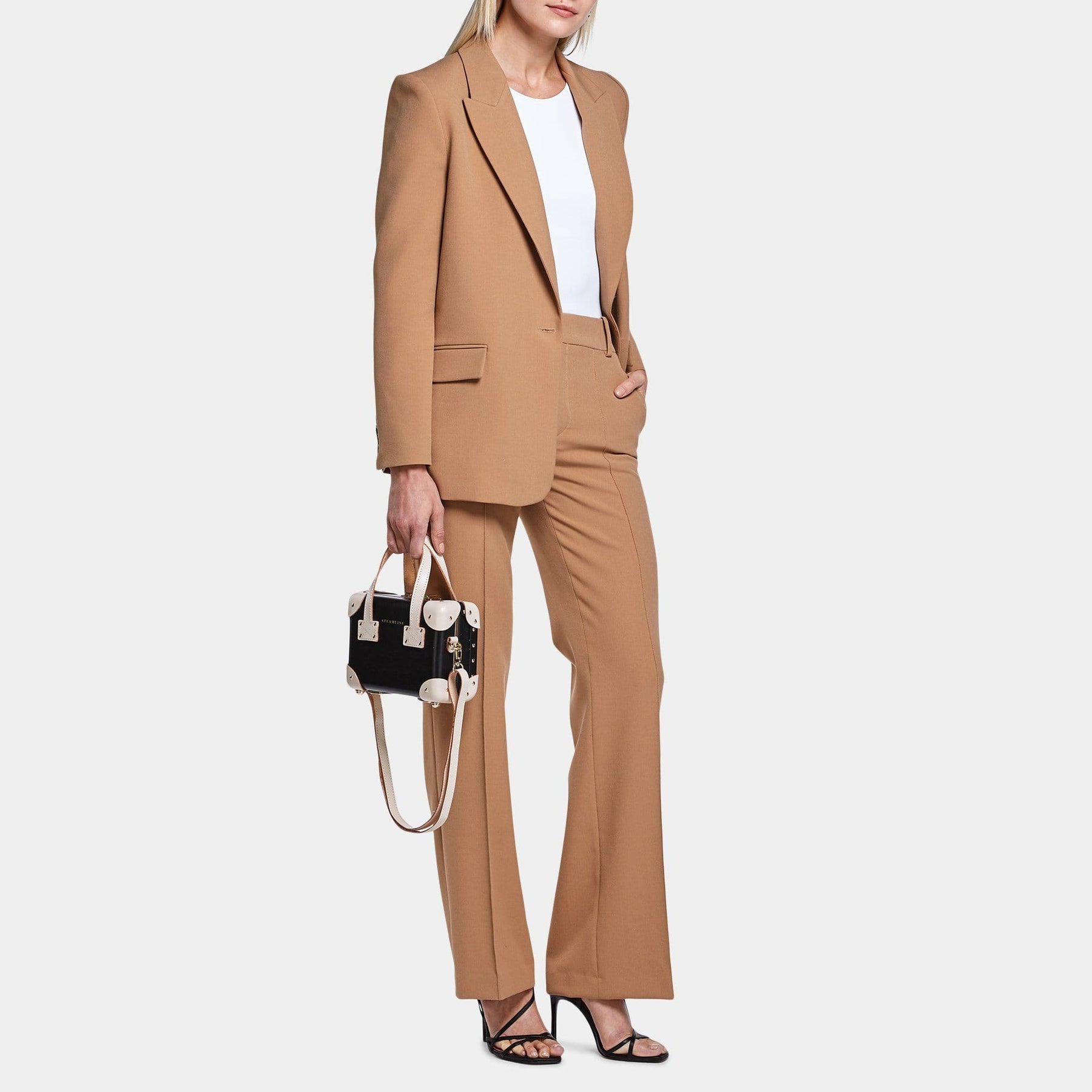 Model with the mini Starlet fibreboard suitcase in black with shoulder attachment strap