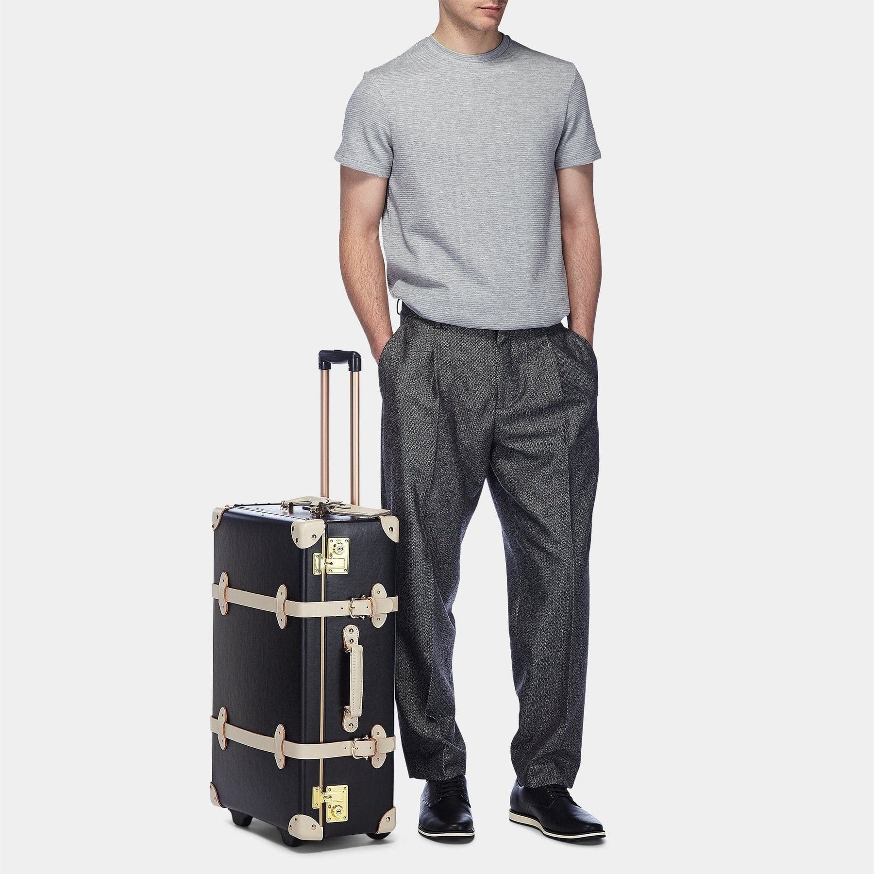Male model with the stowaway Starlet fibreboard suitcase in black with raised handle