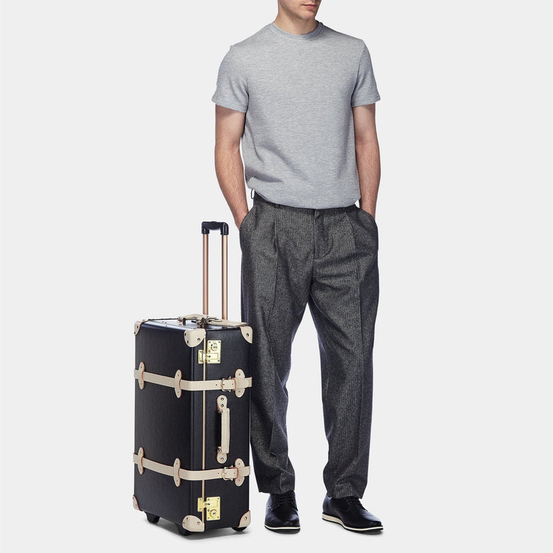 Male model with the stowaway Starlet fibreboard suitcase in black with raised handle