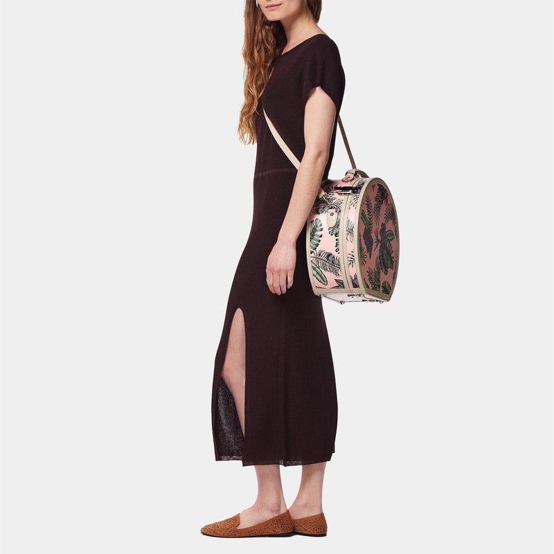 Model with the large hatbox Botanist fibreboard suitcase in pink with shoulder attachment strap