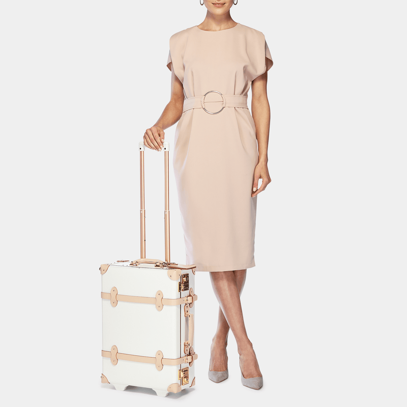 Model with the carry-on Sweetheart fibreboard suitcase in cream with raised handle