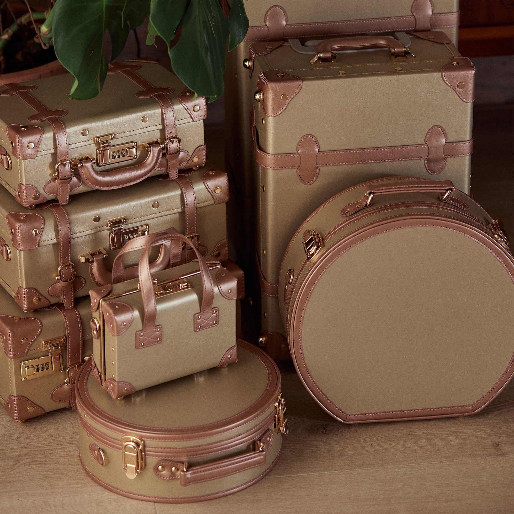 Lifestyle image of The Alchemist vegan leather suitcases in gold