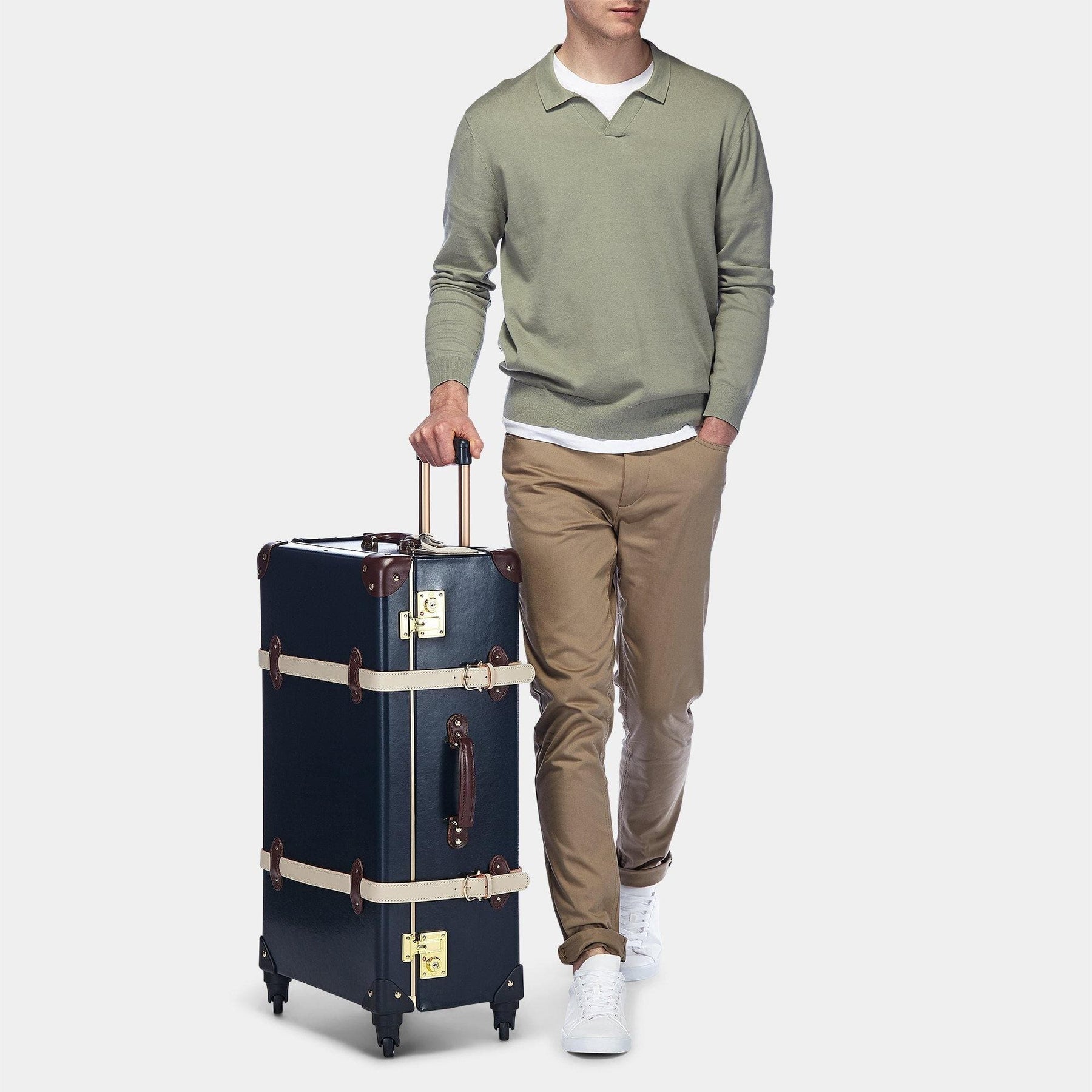 Male model with the check-in Architect leather suitcase in navy with raised handle